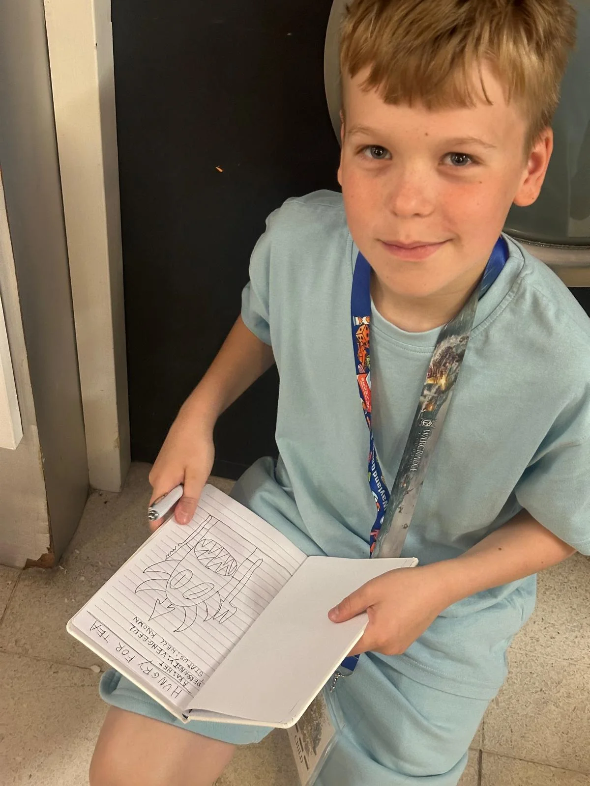 Benjamin sketching in his notebook at UK Games Expo